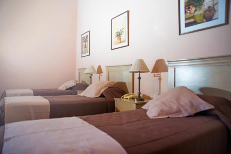 Habitación triple con tres camas individuales y mesita de noche en Posada del Frayle Bentos