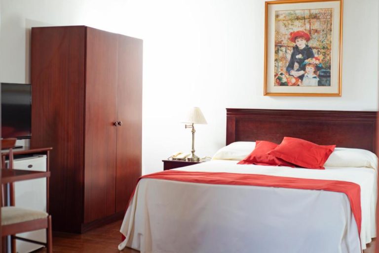 Habitación doble con cama matrimonial y decoración en rojo de Posada del Frayle Bentos