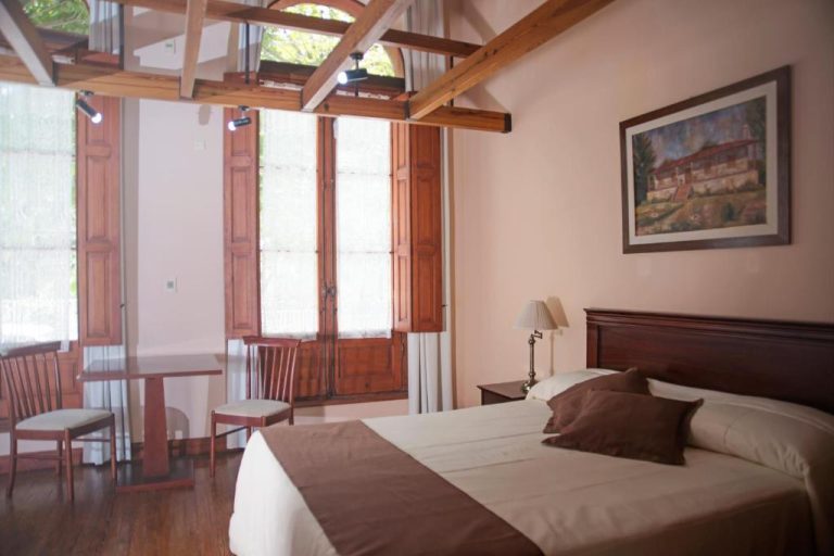 Habitación doble con vigas de madera y ventanas de madera en Posada del Frayle Bentos