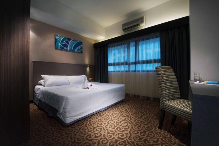 Habitación doble con cama matrimonial y escritorio en Crown Regency Serviced Suites
