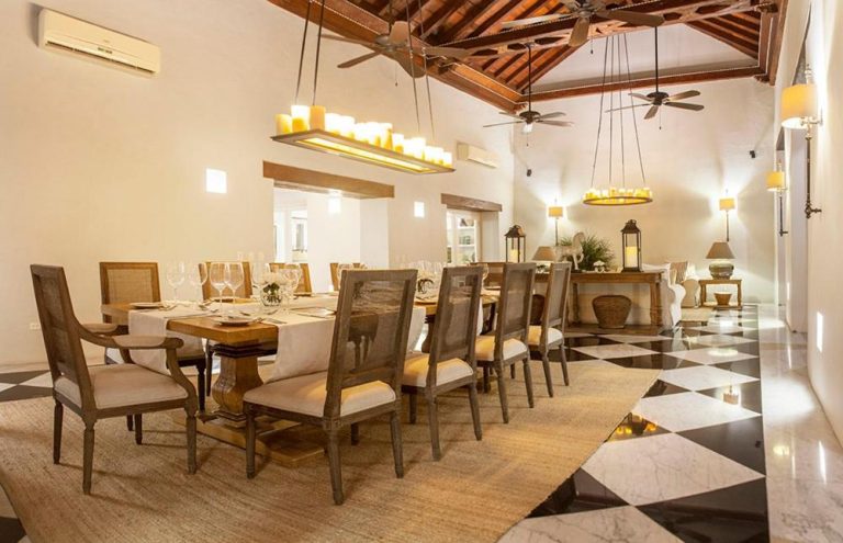 Elegante comedor colonial con mesa larga y candelabros del Hotel Casa Don Sancho By Mustique en Cartagena
