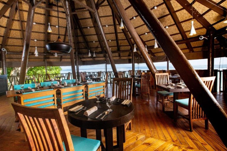 Restaurante con techo de paja y vistas al mar del Coral Strand Smart Choice en Seychelles