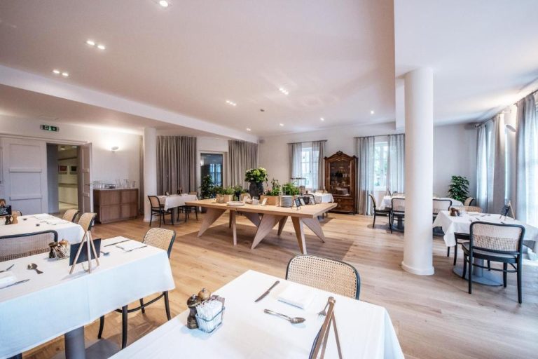 Elegante restaurante del Boutique Hotel Boškinac con mesas blancas y suelo de madera natural