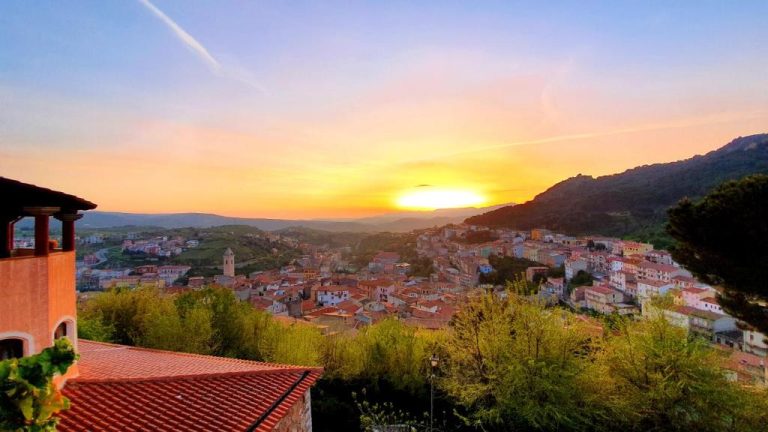 Vista panorámica al atardecer del pueblo desde el Hotel Su Lithu con montañas al fondo