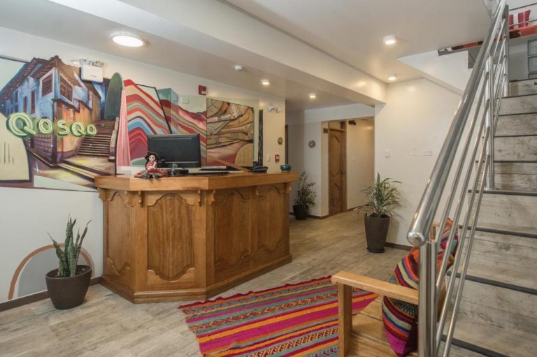 Recepción de Casa Matara Boutique en Cusco con mostrador de madera y murales típicos peruanos