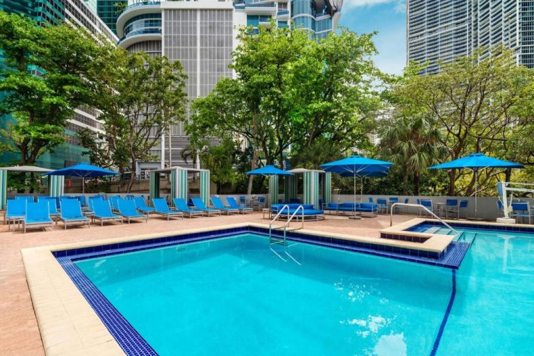 Piscina exterior con tumbonas azules y sombrillas del Hyatt Regency Miami rodeada de rascacielos