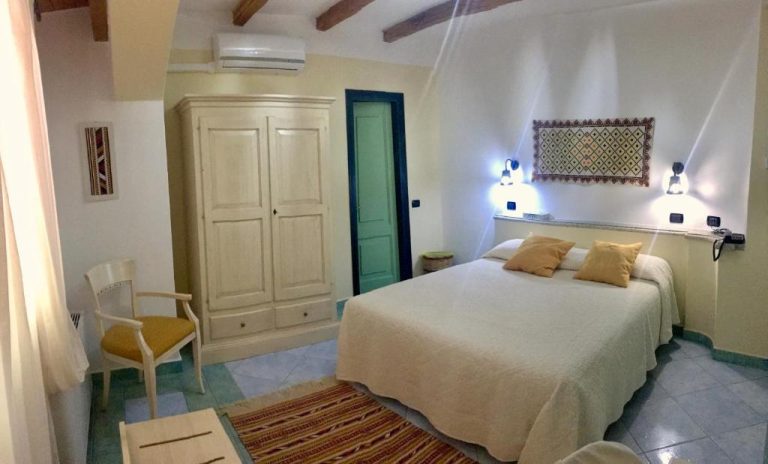 Habitación doble con decoración rústica y vigas de madera en el Hotel Su Lithu
