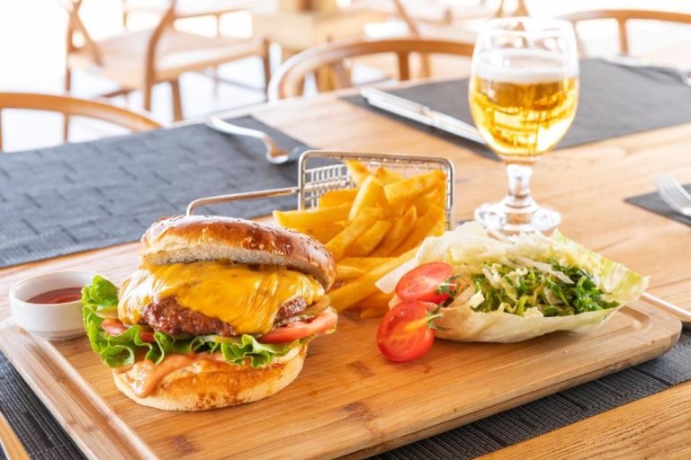 Hamburguesa con queso, patatas fritas y ensalada acompañada de cerveza en el restaurante del Hotel Vita Bella Resort & Spa