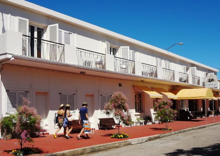 Fachada exterior del Hotel Tamariz con terraza, jardines y zona de descanso en día soleado