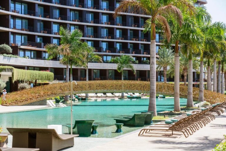 Piscina exterior con tumbonas y palmeras tropicales del Savoy Palace Leading Hotels of the World en Madeira