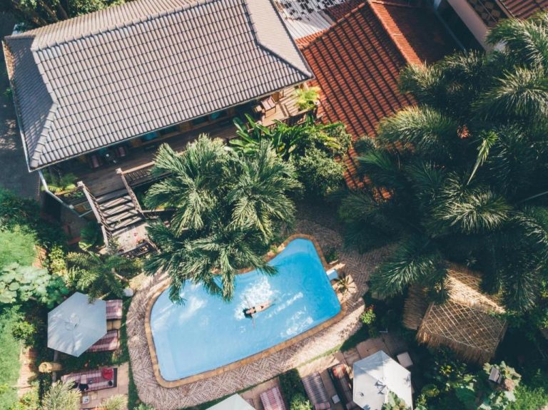 Vista aérea de la piscina exterior rodeada de palmeras en Liam's Guesthouse Adults Only
