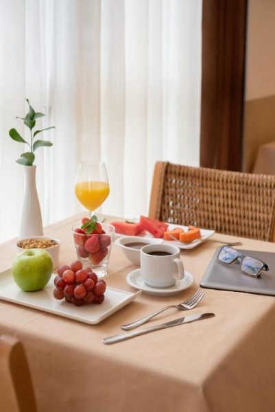 Desayuno continental con frutas frescas, café y zumo de naranja en el Hotel Intercity Florianópolis