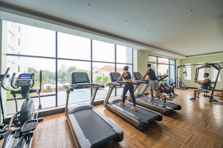 Gimnasio moderno con cintas de correr y máquinas de ejercicio en Kampong Thom Royal Hotel