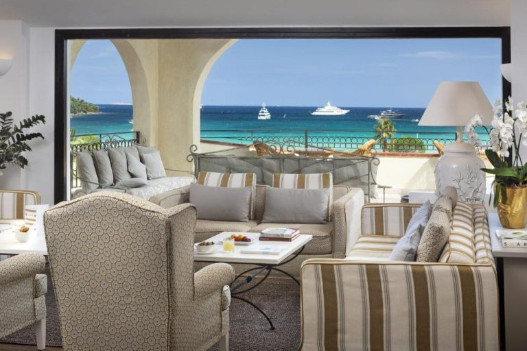 Salón de lujo con vista al mar turquesa y yates en Abi d'Oru Sardinian Beach Resort & Spa