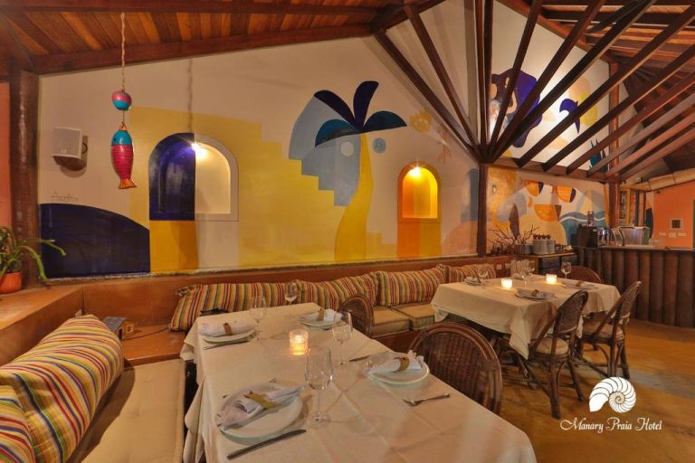 Restaurante del Manary Praia Hotel con murales artísticos coloridos y mesas elegantemente decoradas