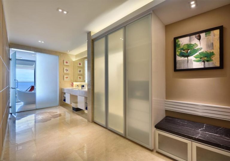 Vestidor con puertas de cristal y baño de lujo en la suite del hotel Lexis Suites Penang
