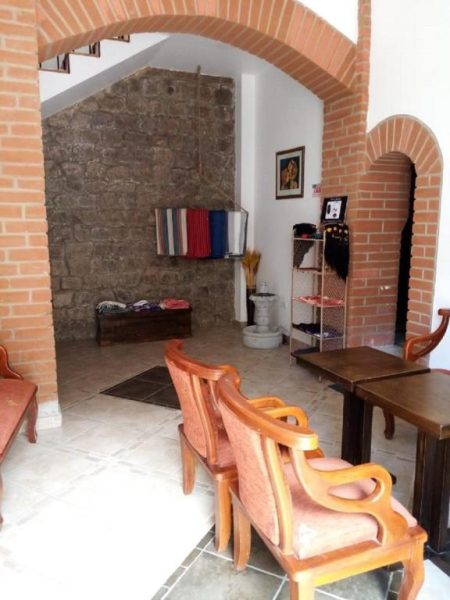 Lobby colonial con arcos de ladrillo y mobiliario de madera en Hotel Casa Ecuatreasures Centro Histórico