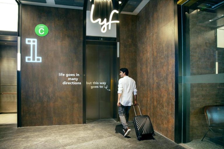 Viajero con maleta dirigiéndose al ascensor en el lobby C del hotel lyf Funan Singapore