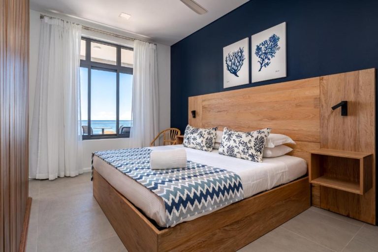 Habitación doble con cabecero de madera y vista al mar en Hotel La Desirade