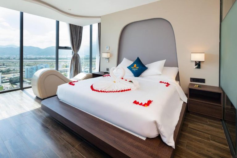 Habitación romántica con decoración de pétalos y cisnes en Amber Hotel managed by HT con vistas a la ciudad