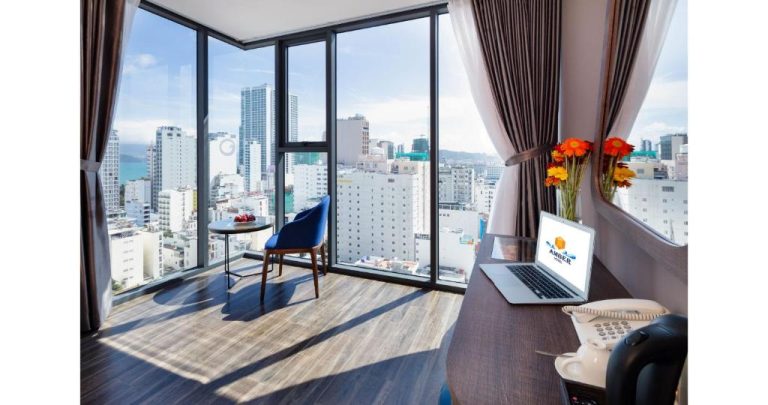Habitación superior con escritorio, laptop y vistas panorámicas a la ciudad en Amber Hotel managed by HT