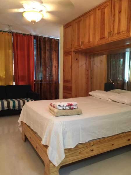 Habitación con cama matrimonial y muebles de madera en Hotel Terraza del Caribe