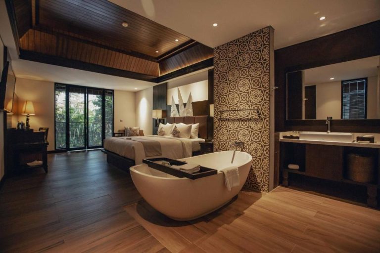 Habitación de lujo con bañera exenta y diseño balinés en The Vira Bali Boutique Hotel & Suite