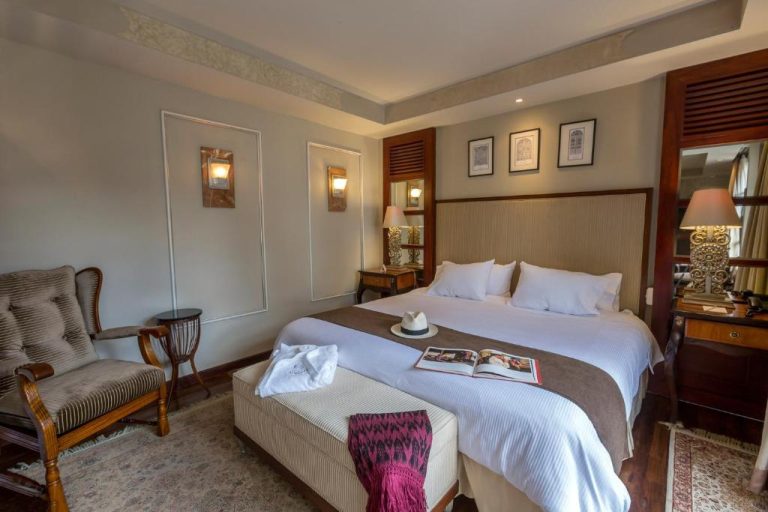 Habitación doble de lujo con cama king size y decoración colonial en Mansion Alcazar