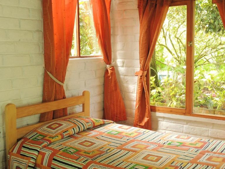 Habitación con cama individual y ventanas con vistas al jardín en Hotel La Casta
