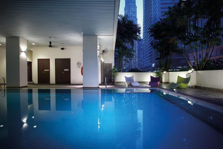 Piscina interior iluminada del Crown Regency Serviced Suites con vistas a las Torres Petronas de Kuala Lumpur