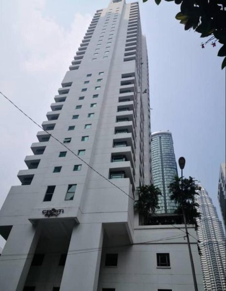 Vista exterior de la torre del Crown Regency Serviced Suites en Kuala Lumpur con edificios modernos al fondo