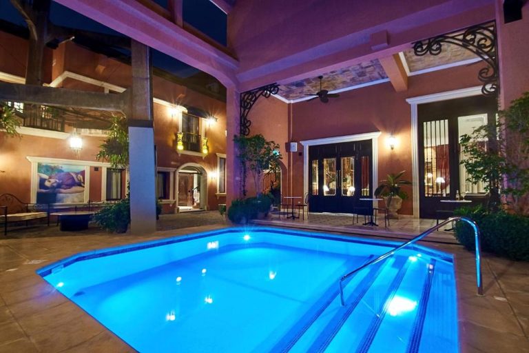 Piscina interior iluminada de noche en el Nino Hotel Boutique con ambiente colonial y elegante