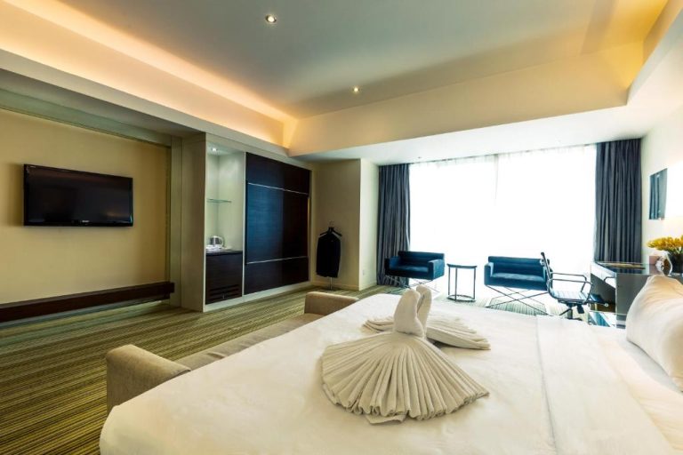 Habitación deluxe con cama king size y decoración de toallas en Ixora Hotel Penang
