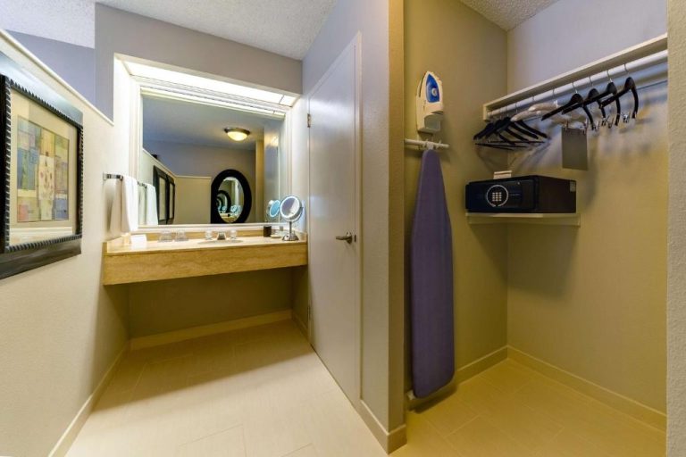 Zona de armario con perchas, plancha y caja fuerte junto al tocador con espejo en Hyatt Regency Miami