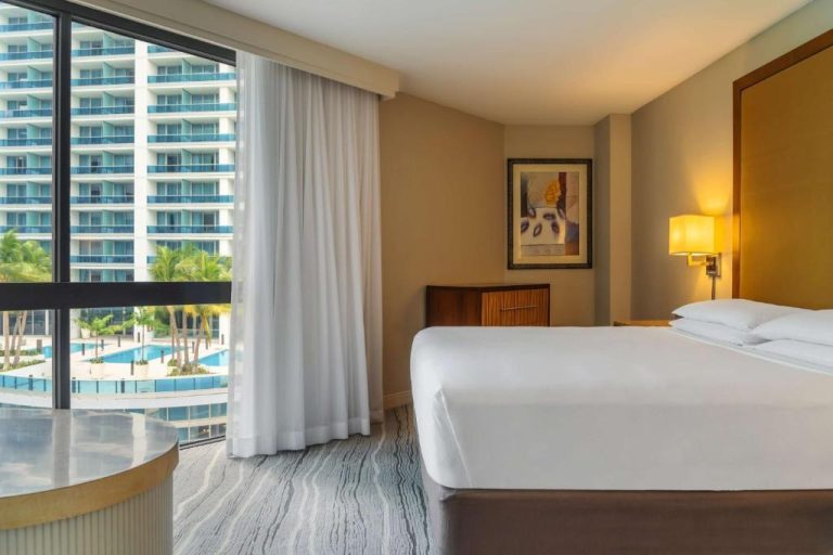Habitación con cama king y vista a la piscina exterior en el Hyatt Regency Miami