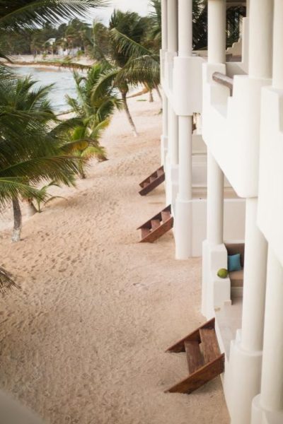 Bungalows frente a la playa de arena blanca con palmeras tropicales en Paamul Hotel, Caribe mexicano