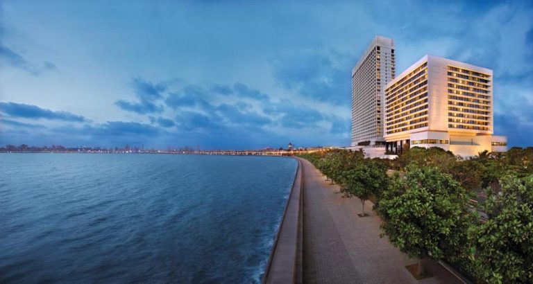 Vista panorámica del The Oberoi Mumbai al atardecer con paseo marítimo y jardines frente al mar