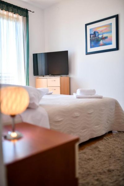 Habitación doble con cama matrimonial y televisión en Levant Residence, decoración moderna y acogedora