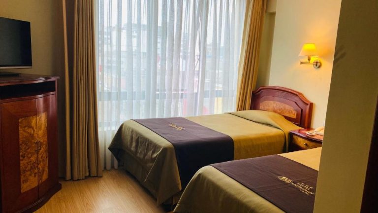 Habitación twin con dos camas y televisor del Hotel Continental Lima con vista a la ciudad
