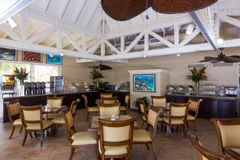 Restaurante buffet de desayuno con mesas y sillas de madera en Comfort Suites Paradise Island