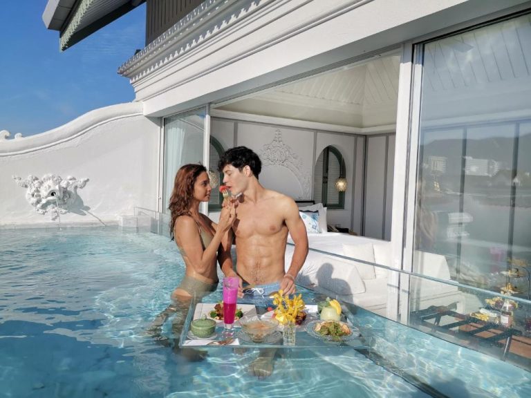 Pareja disfrutando de desayuno flotante en piscina privada con vistas a la habitación en The Inside House