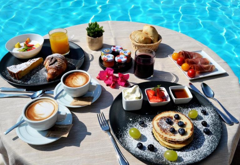 Desayuno buffet junto a la piscina del Hotel Costa dei Fiori con cruasanes, pancakes y café