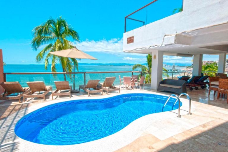 Piscina exterior con tumbonas y vista al mar del Vallarta Shores Beach Hotel en Puerto Vallarta