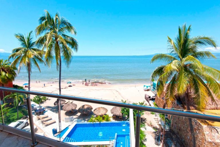Vista desde balcón del Vallarta Shores Beach Hotel con piscina, palmeras y playa en Puerto Vallarta