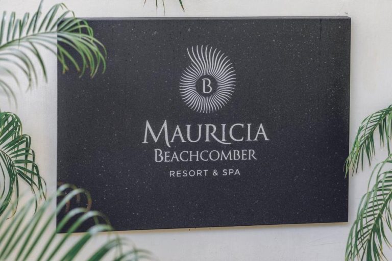 Cartel de entrada al Mauricia Beachcomber Resort & Spa con logo elegante y palmeras decorativas