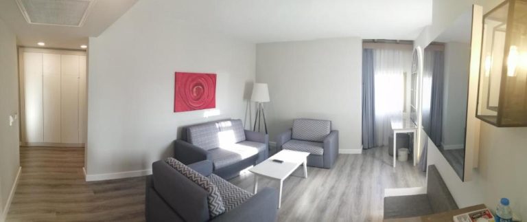 Salón amplio y moderno de suite en Limak Arcadia Sport Resort Belek con sofás y mesa de centro