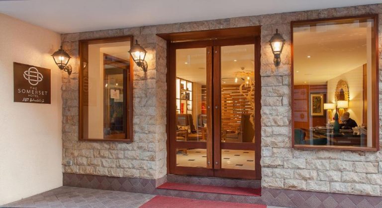 Entrada principal con puertas de madera y fachada de piedra del The Somerset Hotel