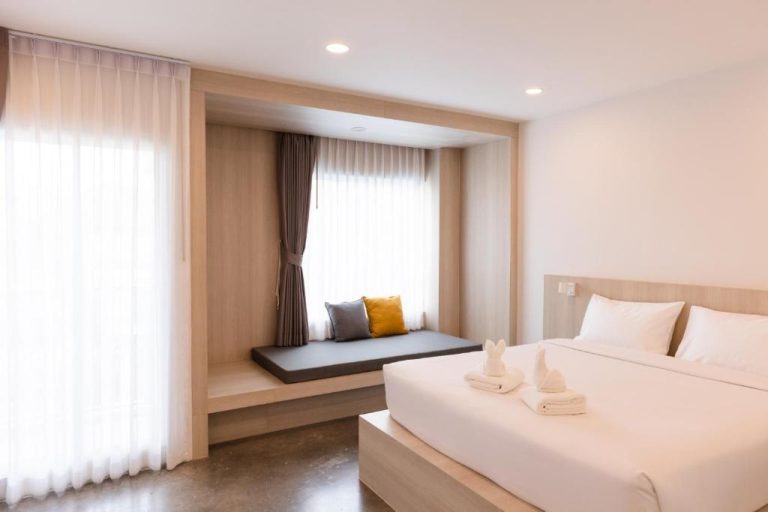 Habitación doble con zona de descanso junto a la ventana y cama king size en Nappiness Hotel