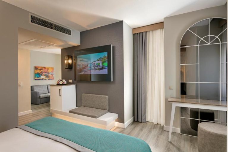 Habitación suite moderna con TV y zona de estar en Limak Arcadia Sport Resort Belek
