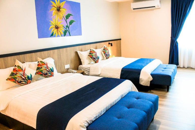 Habitación triple con dos camas dobles y decoración en azul del Savana Hotel & Serviced Apartments